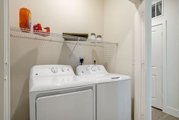 A white double sink bathroom with a white cabinet and a white door.